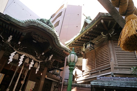 小網神社 境内の社殿と背景のビル群の様子